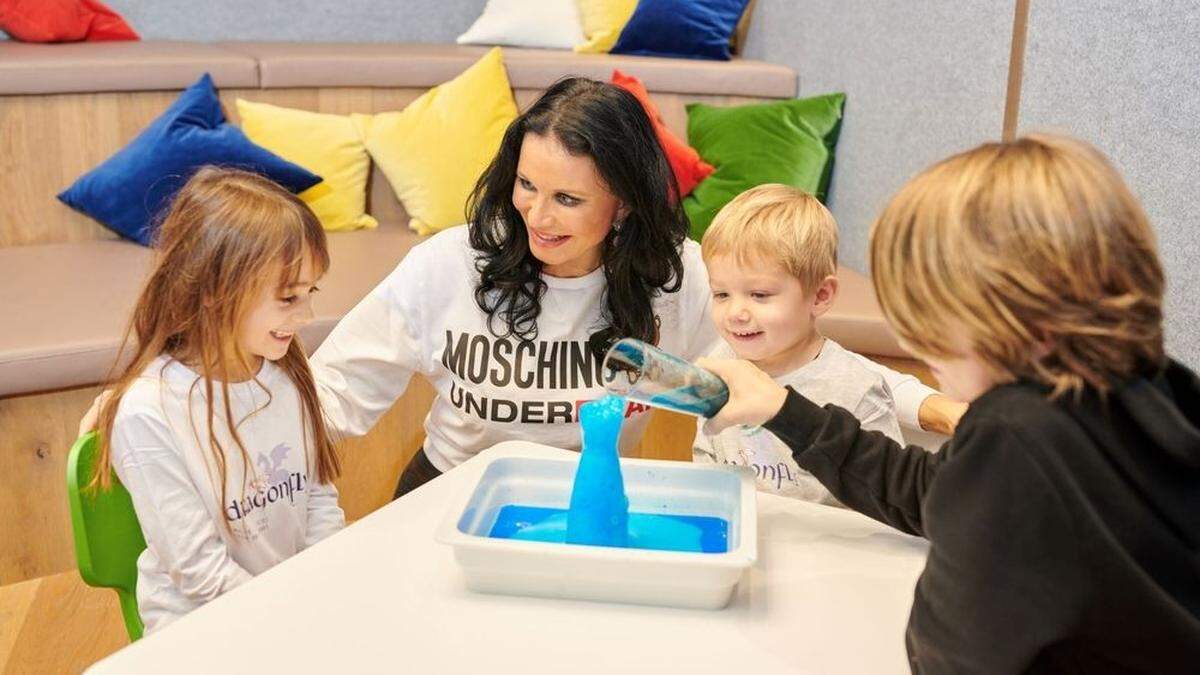 Kindergarten-Gründerin Mirjam Orasch mit Polly, Nino und Laurenz beim Experimentieren	