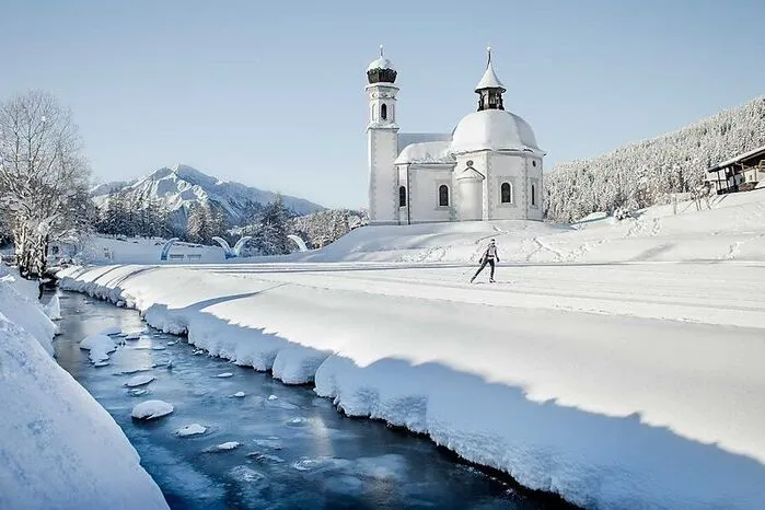 250 Loipenkilometer zählen die fünf Ortschaften der Olympiaregion Seefeld in Tirol auf 1200 Meter Seehöhe. Einige davon sind etwas ganz Besonderes: Für Landschaftsläufer ist die Wildmoosrunde ein Höhepunkt, die wunderschön gelegen am berühmten Seekirchl (im Bild) vorbeiführt. Auf den Hundeloipen sind auch vierbeinige Begleiter willkommen.