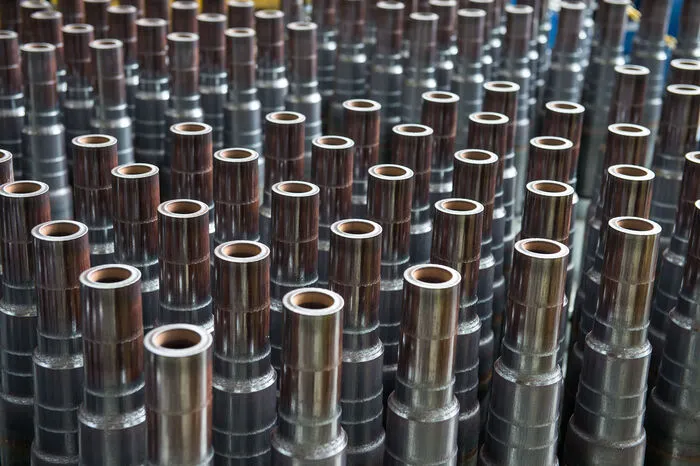 Die Rotec veredelt Rohre. Die rohen Werkstücke werden dabei eingeseift und mit einer Zugkraft von bis zu 30 Tonnen durch eine Matrize zu kleineren Durchmessern gezogen.