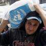 Ein palästinensischer Helfer bei der Verteilung von Nahrungsmitteln für Flüchtlinge in Gaza