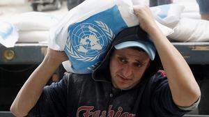Ein palästinensischer Helfer bei der Verteilung von Nahrungsmitteln für Flüchtlinge in Gaza