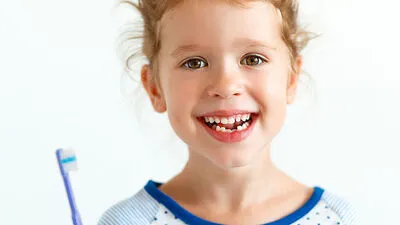 happy child girl smiles with toothbrush