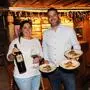 Ein Mann und eine Frau lächeln in eine Kamera. Sie halten Teller voller Essen und ein Glas Wein in der Hand. | Peter Marko und Lisa Seebacher übernahmen 2018 den Landgasthof Seebacher – nun ist er Haubenkoch