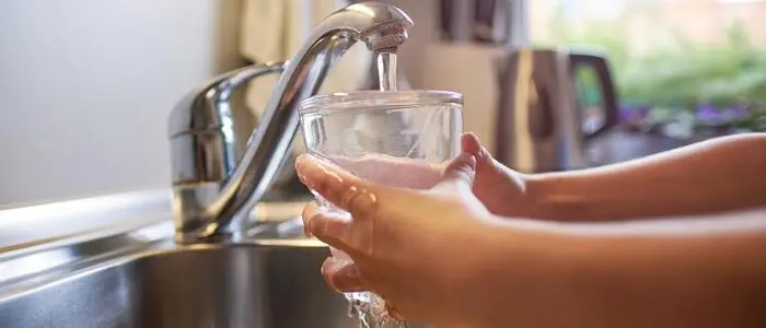 Ein Glas wird mit Wasser aufgefüllt.