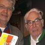 Satiriker Gerhard Polt (links) mit dem Feldkirchner Kulturfreund Werner Mosing und &quot;Leck Buckl&quot;-Büchern in München