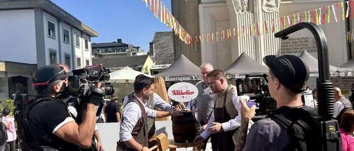 Bieranstich am Festgelände, davor ein Kamerateam