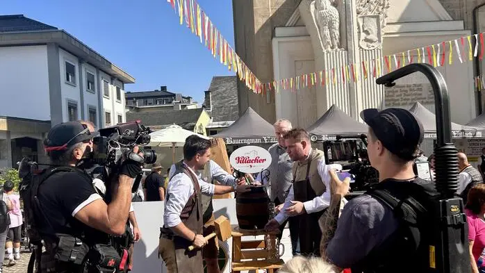 Bieranstich am Festgelände, davor ein Kamerateam
