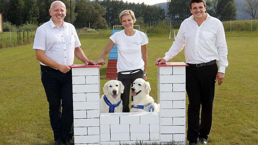 Nicole Hartinger mit den Therapiehunden Polly und Lany, Bürgermeister Franz Jost (r.) und Vize Johann Rath (l.)