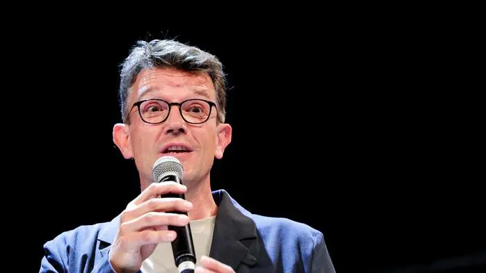 Philipp Pointner bei einer Podiumsdiskussion mit einem Mikro in der Hand