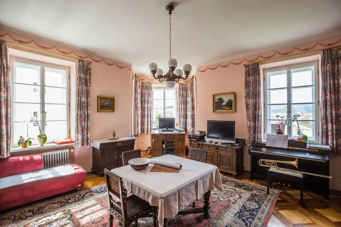 Das Wohnzimmer ist in einem zarten Rosa gehalten.