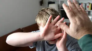 Ein Junge versucht sich vor den Schlägen seines Vaters zu schützen 