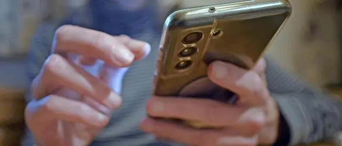 Eine Frau hält ein Telefon in ihrer Hand