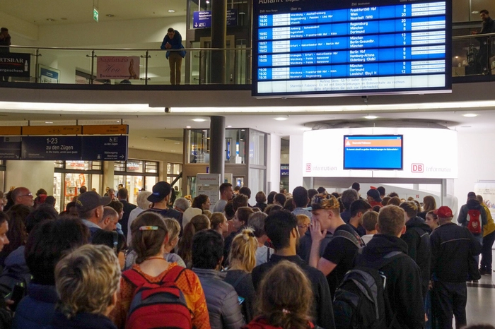 Bayern, Nürnberg: Reisende schauen auf einen Monitor im Hauptbahnhof von Nürnberg auf dem bedingt durch Sturmtief Fabienne auf Einschränkungen im Bahnverkehr hingewiesen wird.