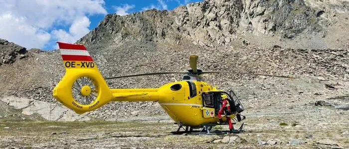 Ein gelber Hubschrauber in einer Bergkulisse und es steigt gerade ein Flugretter ein | Der in Lienz stationierte Notarzthubschrauber Christophorus 7 wurde 2025 insgesamt 753-mal zu Einsätzen alarmiert