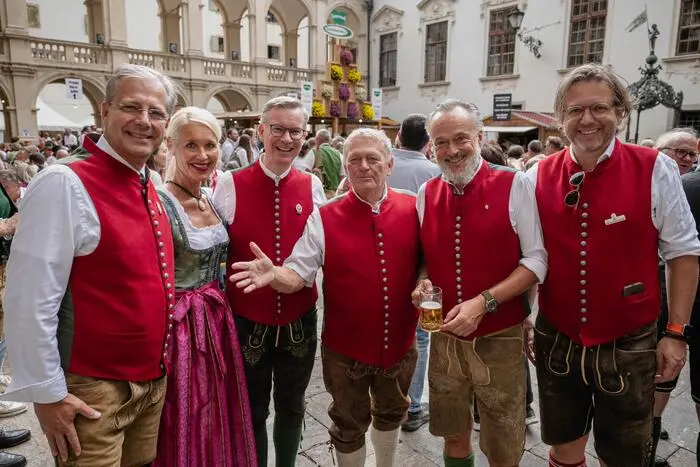 Fünf Männer und eine blonde Frau lachen in die Kamera