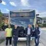 Vier Männer stehen vor einem Bus