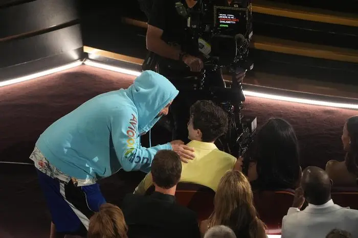 Adam Sandler, left, and Timothee Chalamet in the audience during the Oscars on Sunday, March 2, 2025, at the Dolby Theatre in Los Angeles. (AP Photo/Chris Pizzello)