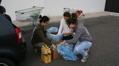 Drei der vier Studentinnen beim Einpacken der Lebensmittel