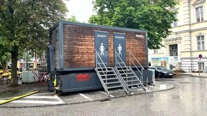 Zu sehen ist ein WC-Container. Zwei Stiegen mit sechs Stufen führen hinauf