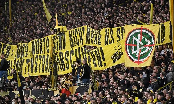 Dortmund's supporter hold on a banner of DFB with a crosshair during the German first division Bundesliga football match Borussia Dortmund v SC Freiburg on February 29, 2020 in Dortmund. (Photo by Ina FASSBENDER / AFP) / DFL REGULATIONS PROHIBIT ANY USE OF PHOTOGRAPHS AS IMAGE SEQUENCES AND/OR QUASI-VIDEO