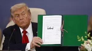 President Donald Trump shows a signed document during the signature ceremony at the Gaza International Peace Summit, in Sharm el-Sheikh, Egypt, Monday, Oct.13 2025. (Yoan Valat, Pool photo via AP)