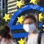 (FILES) In this file photo taken on April 24, 2020, people wearing face masks walk in front of a big Euro sign in Frankfurt am Main, western Germany, as the European Central Bank (ECB) headquarter can be seen in the background, amid the coronavirus COVID-19 pandemic. - The European Central Bank could reiterate on April 30, 2020 its power to do more still to cushion the eurozone economy from the impact of the novel coronavirus, analysts said, while maintaining pressure on governments to agree a joint response. (Photo by Yann Schreiber / AFP)