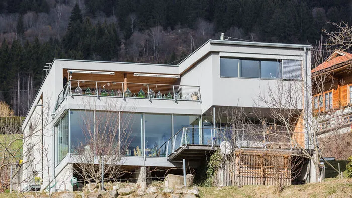 Das Haus mit seinen vielen Glasfassaden ist in einen Hügel eingebettet und war zurzeit der Errichtung eines der ersten Passivhäuser in Kärnten.