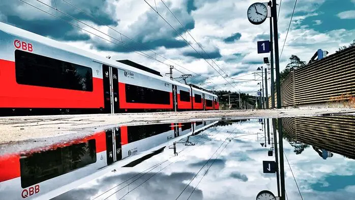 Ein Zug, von einem Bahngleis fotografiert.