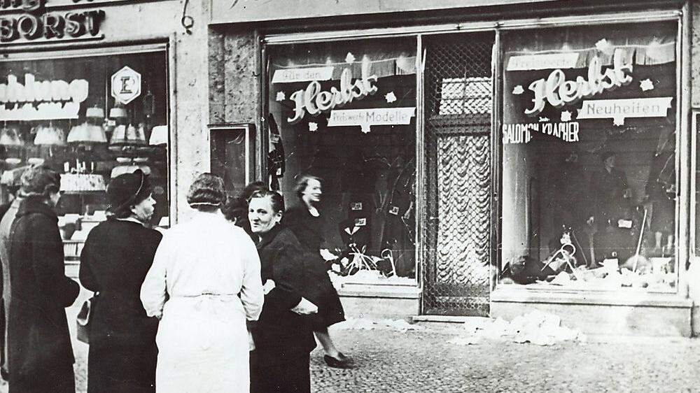 Antisemitismus: Passanten vor einem vor einem zerstörten jüdischen Geschäft