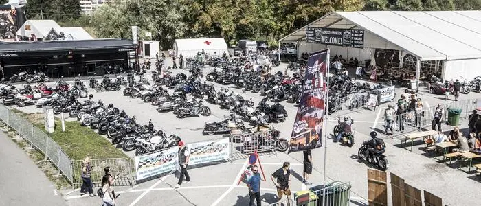 Drohnenaufnahme von einem Festgelände mit vielen geparkten Motorrädern
