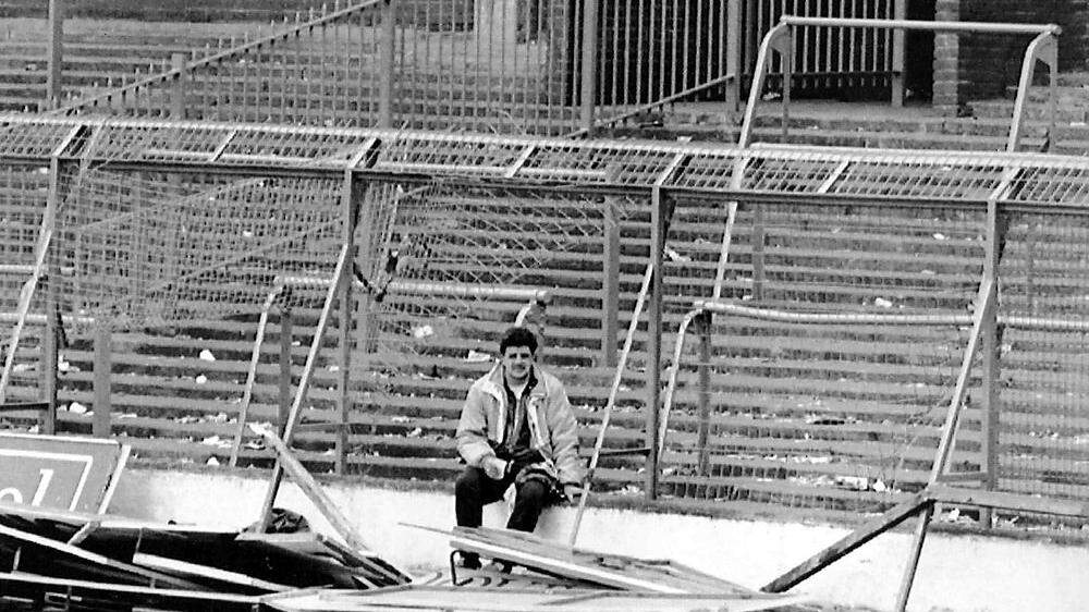 Ein Fußball-Fan sitzt nach der Katastrophe vor den zerstörten Zäunen