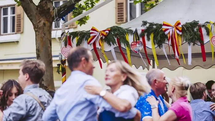 Momentaufnahme auf einem Tanzboden im Freien, wo mehrere Pärchen tanzen