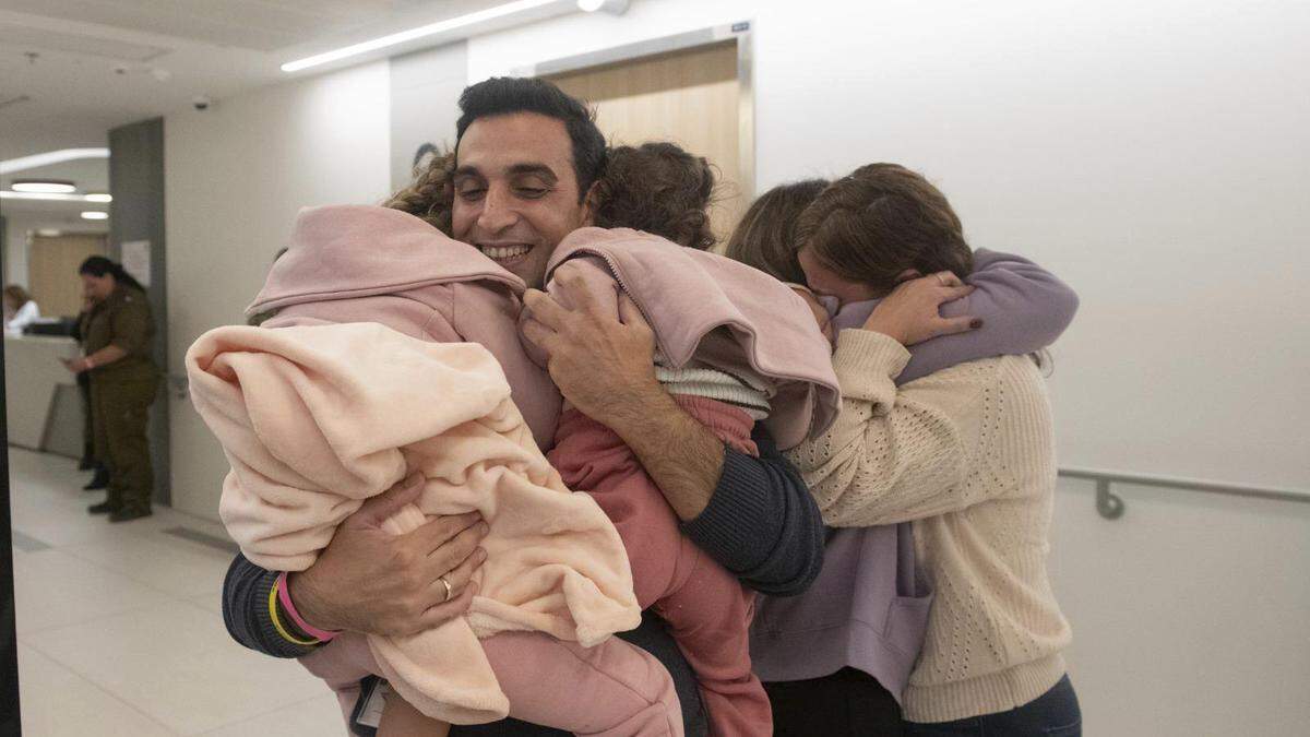 Yoni Asher, nachdem er seine Familie wieder in die Arme schließen konnte | Aviv Asher, 2,5 Jahre alt, ihre Schwester Raz Asher, 4,5 Jahre alt, und Mutter Doron in inniger Umarmung, als sie Yoni, Dorons Ehemann und ihren Vater, endlich wieder treffen