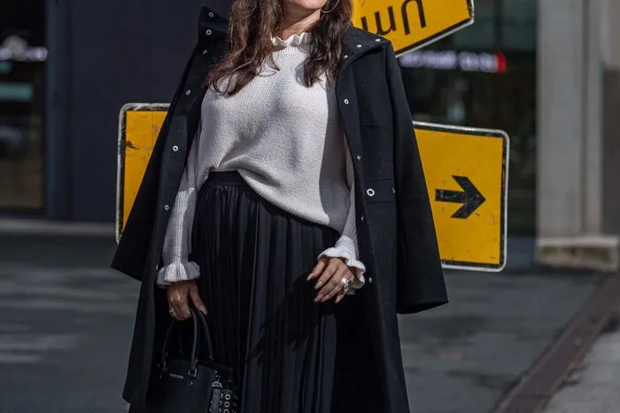 Trends müssen nicht immer schrill und ausgefallen sein. Das zeigt Doris Embacher (@missclassycom). Fließende Plisseestoffe eignen sich in Kombination mit Mantel und Ballonmütze auch sehr gut für verregnete Herbsttage.