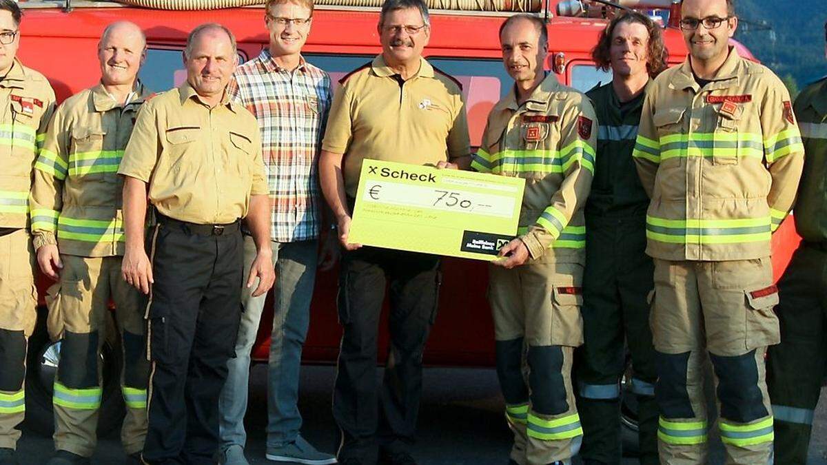 Scheckübergabe. Christian Brugger, Andreas Glantschnig, Bezirksfeuerwehr-Inspektor  Franz Brunner, Hubert Stotter  jun., Bezirksfeuerwehrkommandant Herbert Oberhauser, Florian Meier Florian, Jürgen Fuchs, Andreas Guggenberger und, Michael Schlemmer (von links) 