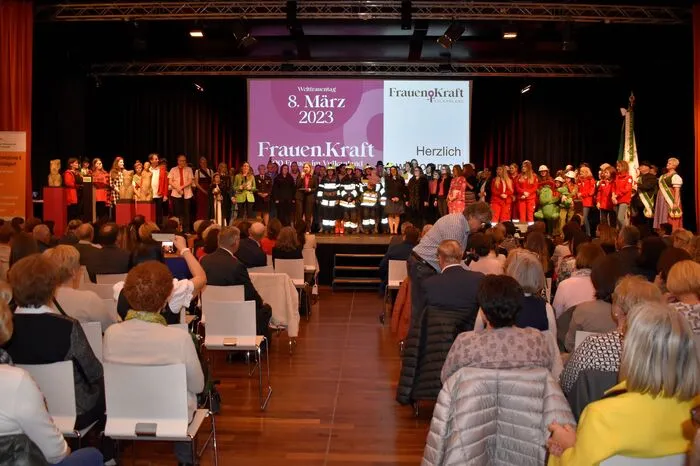 Zu Beginn versammelten sich auf der Bühne zahlreiche Frauen, etwa aus den Musikvereinen, von den Freiwilligen Feuerwehren, vom Roten Kreuz, dem ÖKB, der Polizei, dem Bundesheer, der Berg- und Naturwacht, aus Vereinen wie der Vulkanland Dichtergilde oder auch von Zonta und Innova.