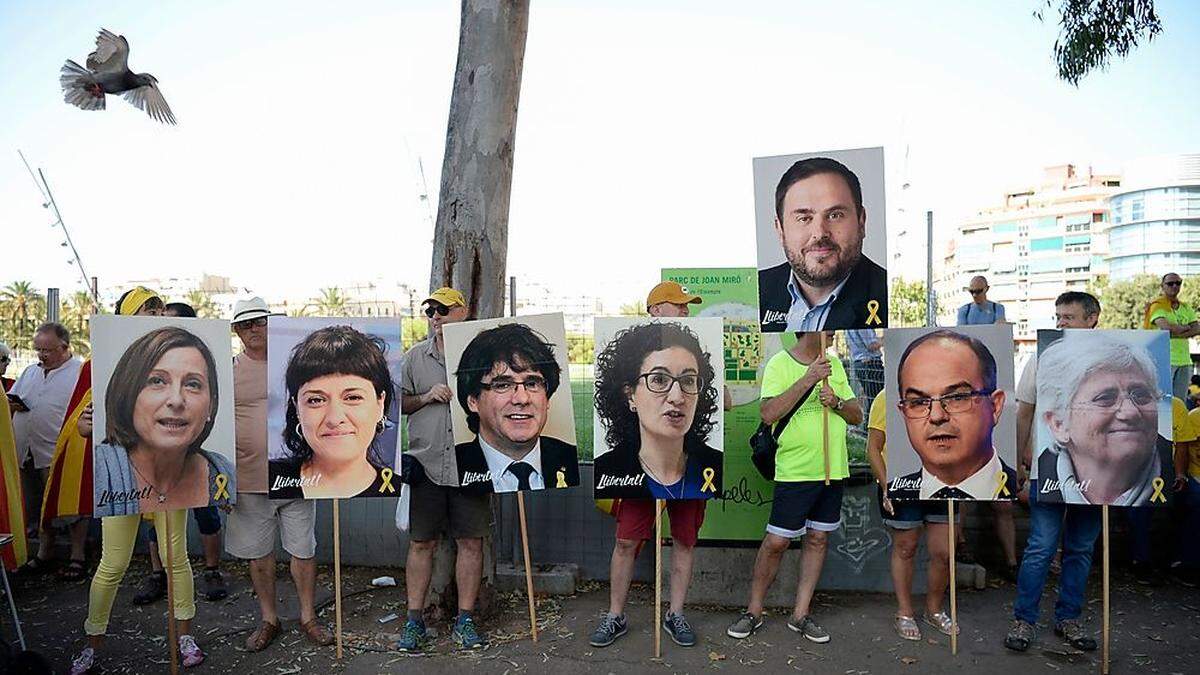 Demonstranten in Barcelona mit Fotos von Separatisten, die entweder im Exil oder in Haft sind 