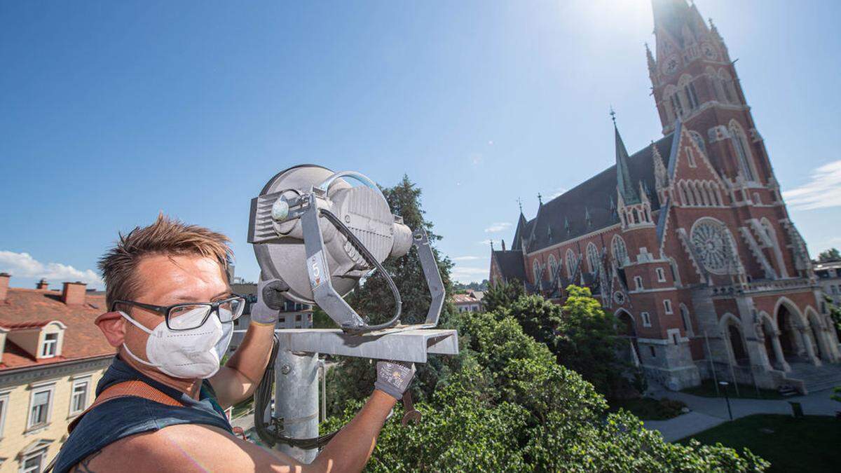 Michael Hofbauer von der Energie Graz beim Austauschen der Scheinwerfer, die die Herz-Jesu-Kirche anstrahlen