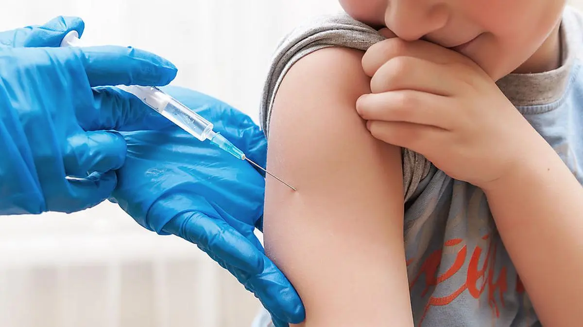 Boy and vaccine syringe