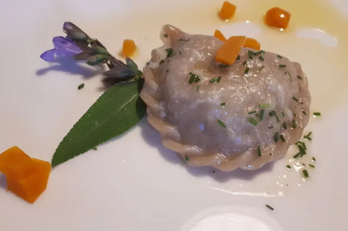 Einen traditionellen Schlipfkrapfen mit Kartoffelfülle und Alpenkräutern kann man beim Restaurant im Alpenhof Wanderniki verkosten.