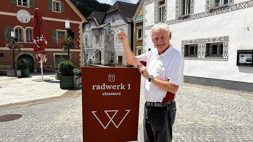 Gerhard Niederhofer vom Museumsverein Eisenerz mit einem der 19 Radwerksfahnen, die im Zentrum den Weg zum Bergmannsplatz säumen