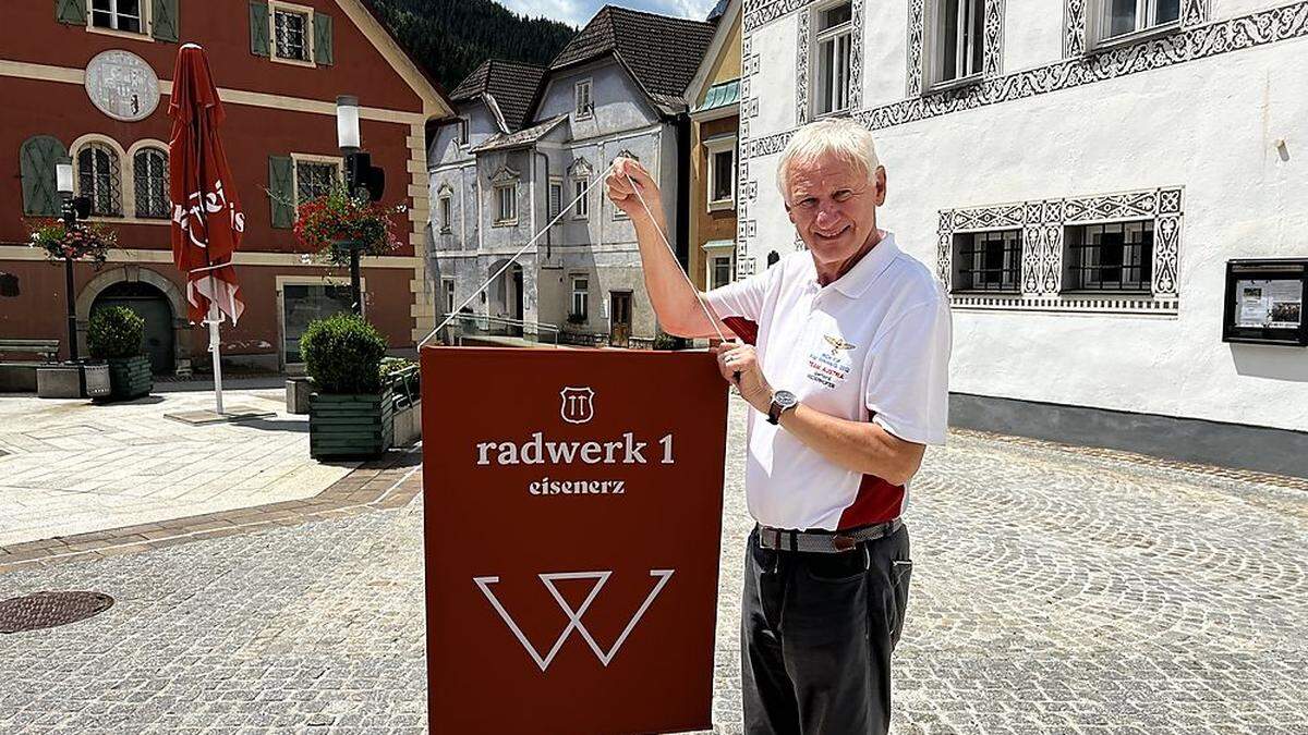 Gerhard Niederhofer vom Museumsverein Eisenerz mit einem der 19 Radwerksfahnen, die im Zentrum den Weg zum Bergmannsplatz säumen