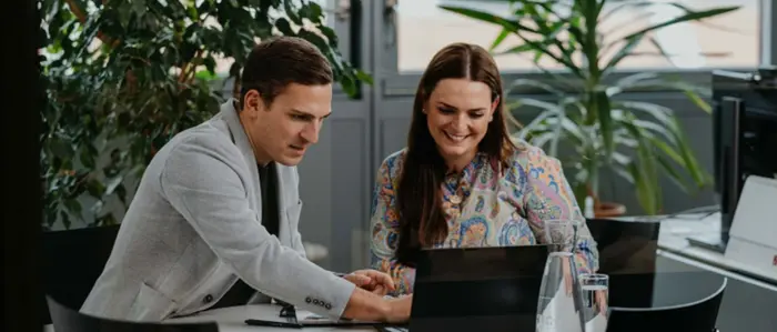 Ein Mann und eine Frau schauen in einen Laptop