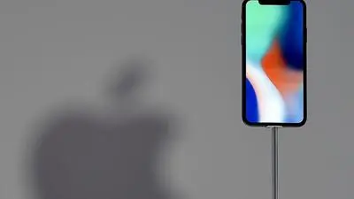 An iPhone X is seen on display during a media event at Apple's new headquarters in Cupertino, California on September 12, 2017.  / AFP PHOTO / Josh Edelson