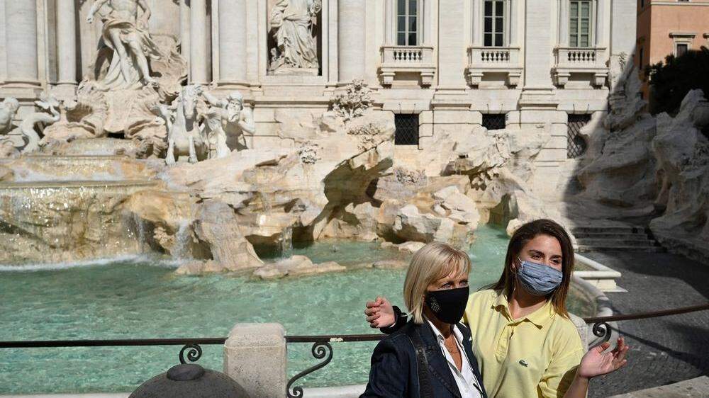 Touristinnen posen vor dem berühmten Trevi-Brunnen in Rom