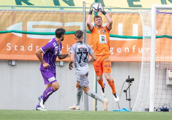 KLAGENFURT,AUSTRIA,25.JUL.21 - SOCCER - ADMIRAL Bundesliga, SK Austria Klagenfurt vs Wolfsberger AC. Image shows Kosmas Gkezos (A. Klagenfurt), Amar Dedic and Manuel Kuttin (WAC).  Photo: GEPA pictures/ Wolfgang Jannach