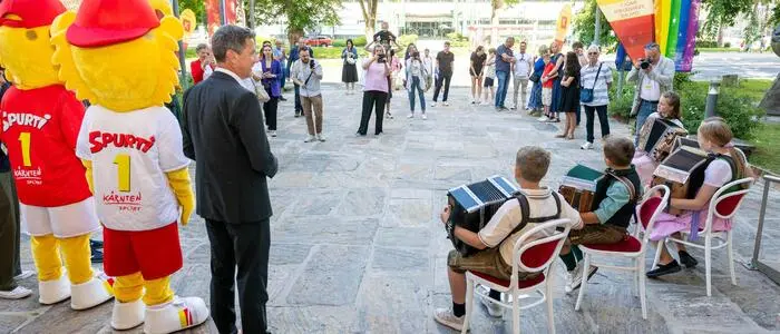 Man sieht etliche Menschen und den Landeshauptmann am Vorplatz der Kärntner Landesregierung
