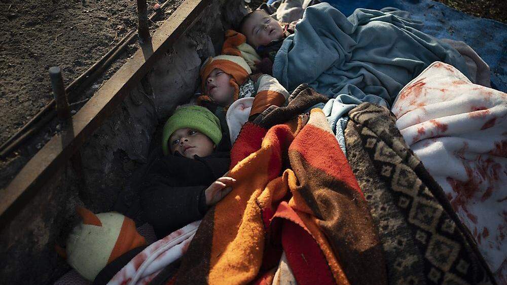 Kinder schlafen auf der kalten Erde an der türkisch-griechischen Grenze