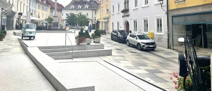 Am Bild sieht man die verschiedenen historischen Gebäude und viel Beton sowie Autos 