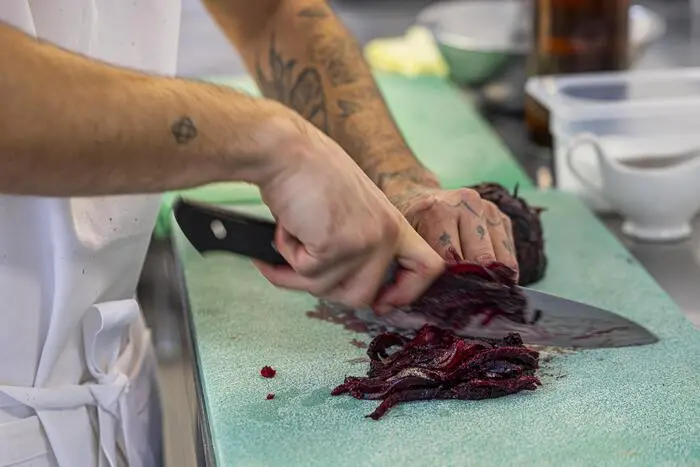 Die Dry-aged-Rübe wird kleingeschnitte und kommt mit den anderen Zutaten mariniert in die Rote-Rübe-Schüssel.